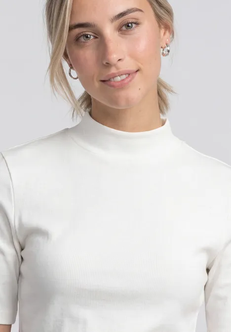 Shirt met col in ribbelpatroon off white Jonge vrouw met blond haar in staart, subtiele glimlach, witte coltrui met korte mouwen.