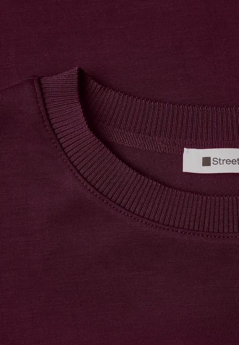 T-Shirt mit Rundhals im Silk-Look rustic rouge Nahaufnahme eines burgunderroten T-Shirts mit Rundhalsausschnitt und Label 'Street'.