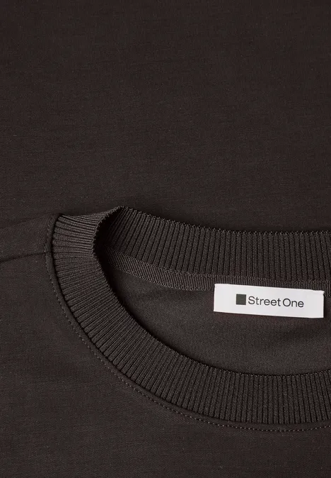 T-Shirt mit Rundhals im Silk-Look black coffee Nahaufnahme eines schwarzen T-Shirts mit Rundhalsausschnitt und 'Street One'-Etikett im Nacken.