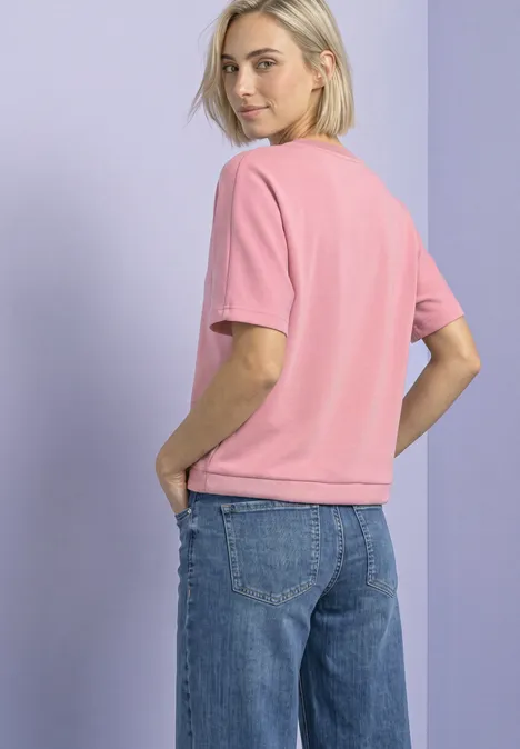 T-Shirt mit Rundhals im Silk-Look vintage blush Junge Frau in pinkem T-Shirt und blauen Jeans, leicht seitlich stehend.