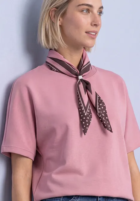 T-Shirt mit Rundhals im Silk-Look vintage blush Frau in rosa Shirt mit kurzem Ärmel und gepunktetem Seidentuch am Hals vor hellem Hintergrund.