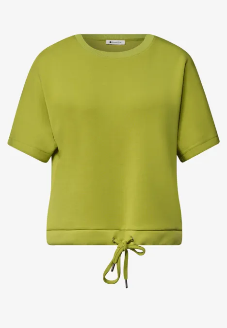 T-shirt court à manches courtes vert clair avec encolure ronde et cordon à la taille.