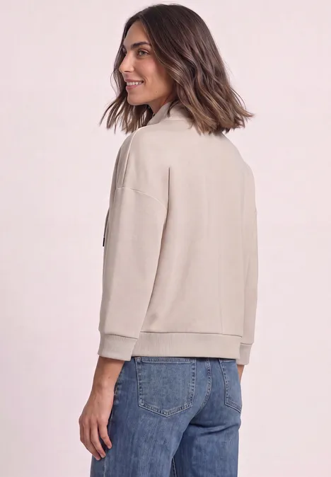 Jacke im Silk-Look mit Rippdetails clay sand Frau in beiger Jacke und Jeans blickt lächelnd über die Schulter.