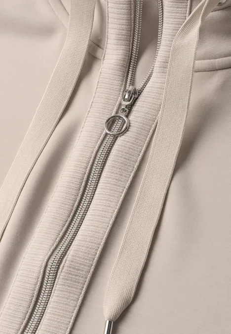 Jacke im Silk-Look mit Rippdetails clay sand Nahaufnahme eines beigen Kapuzenpullovers mit Reißverschluss und Kordelzügen.