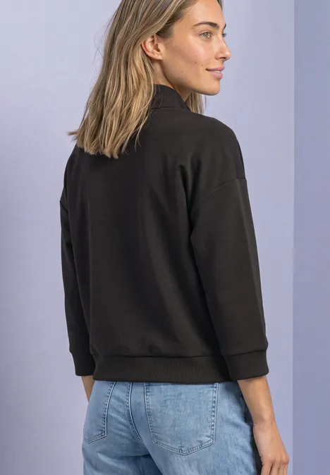 Jacke im Silk-Look mit Rippdetails black coffee Frau von hinten in schwarzer Jacke und blauen Jeans, leicht zur Seite schauend vor hellem Hintergrund.