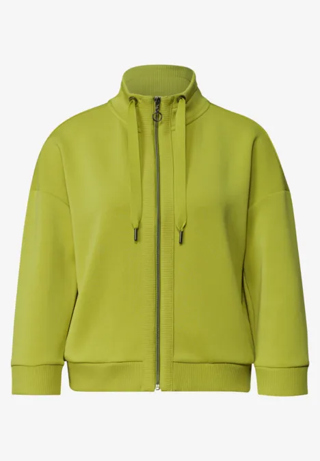 Veste ample vert clair zippée sur l’avant, col montant et cordons de serrage.