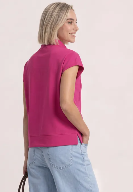 Mouwloos shirt met Silk-Look en ritssluiting magenta dream Frau in pinkem Oberteil mit kurzen Ärmeln schaut seitlich, Rücken sichtbar.