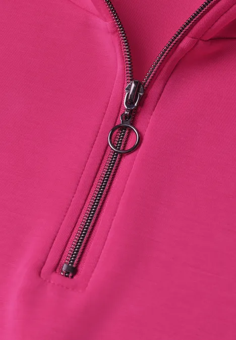 Mouwloos shirt met Silk-Look en ritssluiting magenta dream Nahaufnahme eines pinken Pullis mit schwarzem Reißverschluss und rundem Zipper-Anhänger.