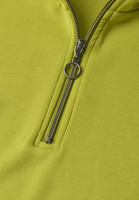 Mouwloos shirt met Silk-Look en ritssluiting apple lime Close-up van een lichtgroen kledingstuk met rits en ronde ritstrekker.