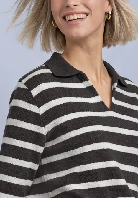 Polo met 3/4-mouwen en streepjespatroon black coffee Vrouw met kort blond haar en zwart-wit gestreept poloshirt, glimlachend