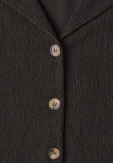 Shirt met verschillende texturen en een knoopsluiting black coffee Zwarte, gestructureerde blazer voorkant met drie crème knopen in close-up.