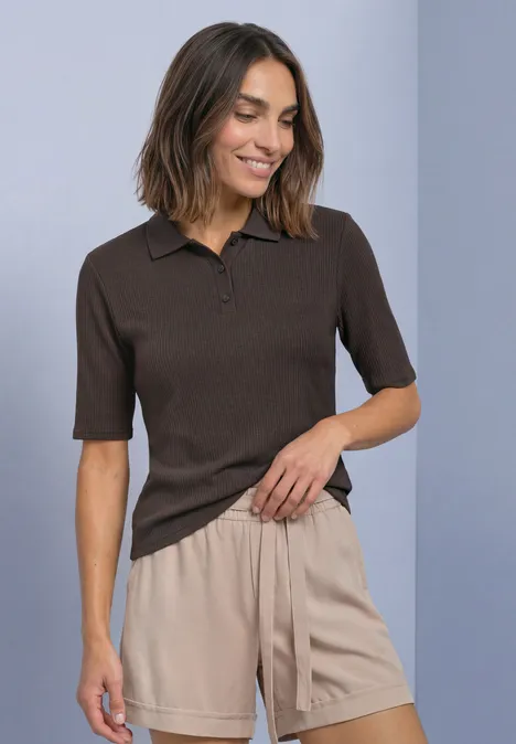 Poloshirt met gebreide look en geribbelde structuur black coffee Vrouw met bruin polo-T-shirt met korte mouwen en beige short, glimlachend met hand in de zak.