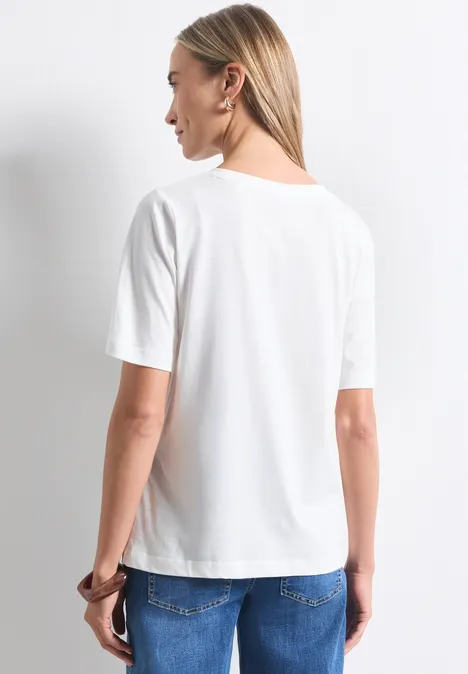 Shirt met ronde hals en fotoprint off white Eine Frau steht mit dem Rücken zur Kamera, trägt ein weißes T-Shirt und blaue Jeans.