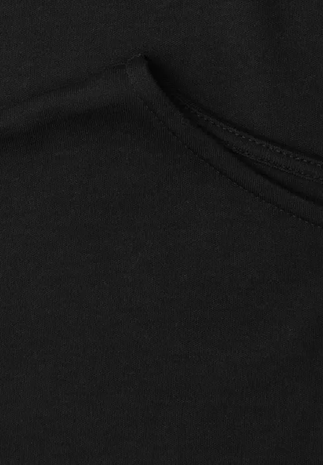 Nahansicht eines schwarzen Kleidungsstücks aus Baumwollstoff mit sichtbarer Naht und Tasche.