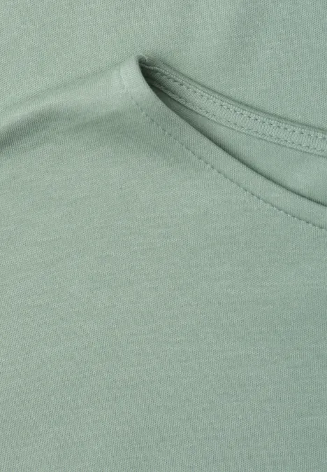 Close-up einer hellgrünen Baumwoll-T-Shirt-Partie mit Rundhalsausschnitt und feiner Naht