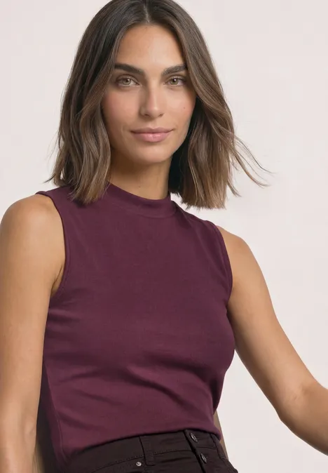 Top im Silk-Look mit Turtle Neck rustic rouge Frau mit schulterlangem braunem Haar trägt ärmelloses weinrotes Oberteil mit Stehkragen.
