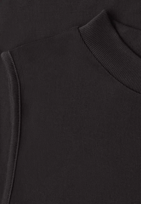 Top in Silk-Look met coltrui black coffee Close-up eines schwarzen gerippten Stoffoberteils mit Kapuze.