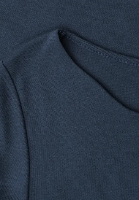 Gros plan d'un t-shirt bleu foncé avec une couture apparente