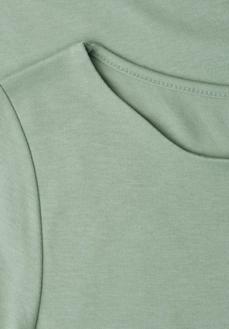 Nahaufnahme eines hellgrünen T-Shirts mit Rundhalsausschnitt und feiner Naht