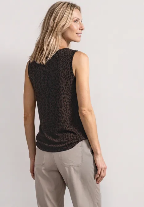 Top met V-hals en decoratief detail molten earth Frau von hinten im schwarzen ärmellosen Top mit feinem Muster und hellen Hosen.