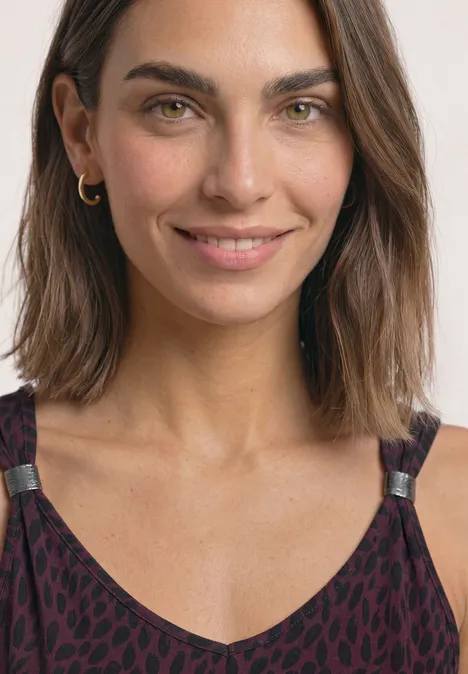 Top mit V-Neck und Dekodetail rustic rouge Frau mit schulterlangen braunen Haaren, grünen Augen und leopardgemustertem Top lächelt in Kamera.