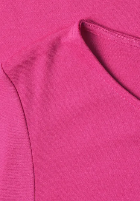 Close-up van een felroze T-shirt met V-hals en schoudernaden