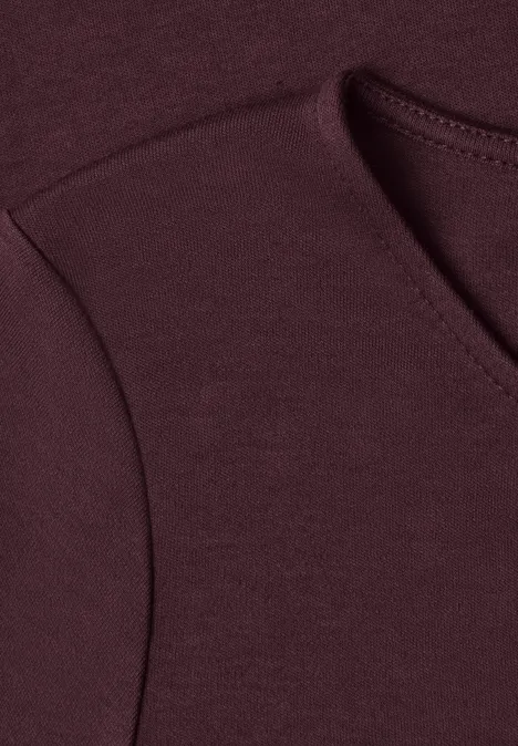 Nahaufnahme eines burgunderfarbenen Pullover-Ausschnitts.