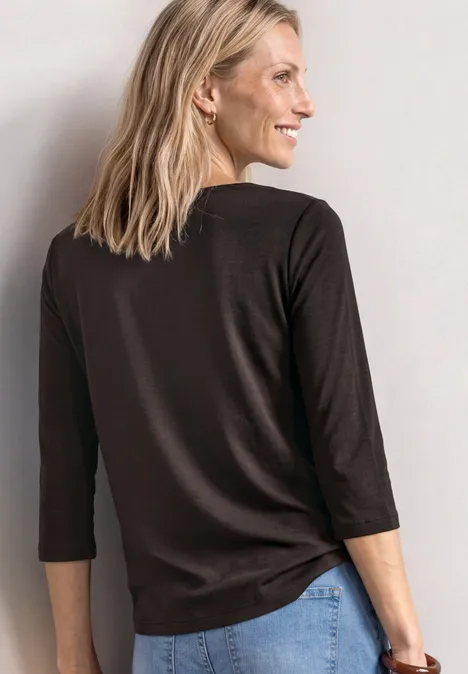 Shirt met 3/4-mouwen en een boothals black coffee Vrouw met blond haar draagt een bruin 3/4-mouwshirt en spijkerbroek, glimlachend in profiel