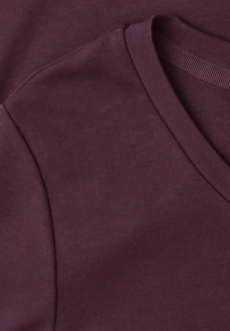 Nahaufnahme eines burgunderfarbenen T-Shirts mit V-Ausschnitt.