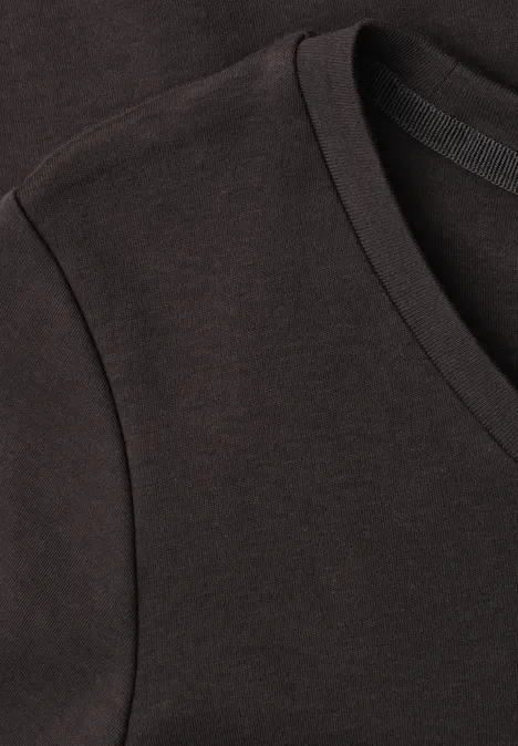 Nahaufnahme eines schwarzen V-Ausschnitt-T-Shirts aus Baumwollstoff mit feiner Naht an Schulter und Halsbündchen.