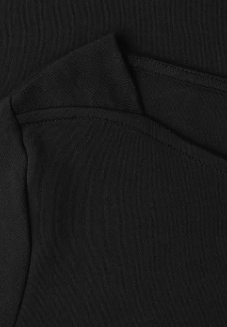 3/4-Arm Shirt mit U-Boot-Ausschnitt Black Nahaufnahme eines schwarzen Kleidungsstücks mit sichtbarer Naht und Tasche.