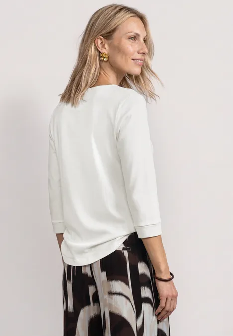 3/4-Arm Shirt mit U-Boot-Ausschnitt off white Rückansicht einer Frau im weißen Dreiviertelärmelshirt und gemusterter Hose