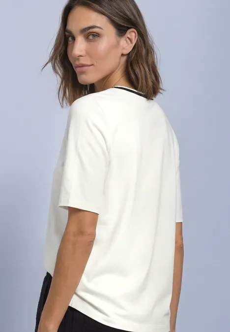 T-Shirt mit Rundhals und Kontrastdetail off white Frau mit kurzem braunen Haar trägt ein weißes T-Shirt und blickt über ihre Schulter.