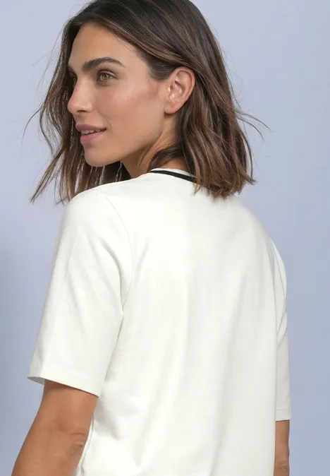 T-Shirt mit Rundhals und Kontrastdetail off white Eine Frau mit schulterlangen braunen Haaren trägt ein schlichtes weißes T-Shirt und blickt seitlich.