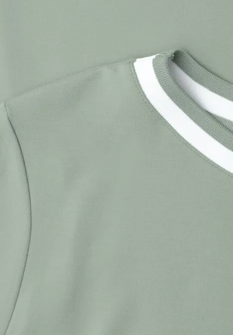 Shirt met ronde hals en contrasterende details eucalyptus green Nahe Ansicht eines ärmellosen, hellgrünen Oberteils mit weißem Doppelstreifen am Rundhalsausschnitt.