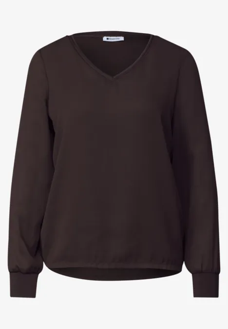 Dunkelbraune Damenbluse mit V-Ausschnitt und langen Ärmeln, legerem Schnitt und elastischen Bündchen.