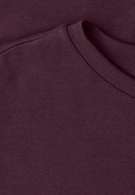 Nahaufnahme eines burgunderroten Sweatshirt-Kragens aus weichem Stoff.
