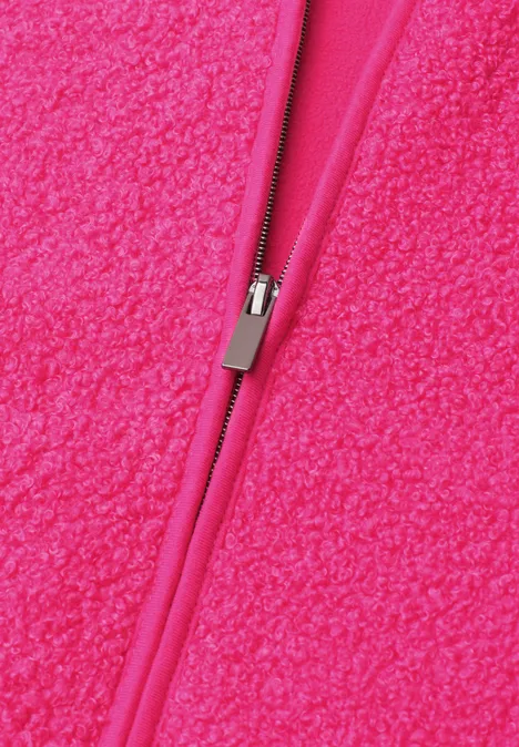 Close-up van een felroze ritssluiting op een pluizige fleece stof.