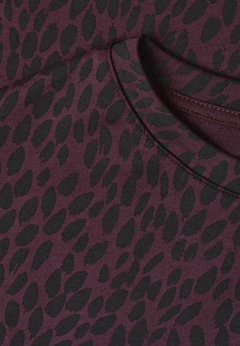 Batwing-shirt met ronde hals en print rustic rouge Close-up van een bordeaux shirt met zwart, organisch patroon en ronde hals.