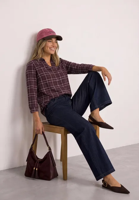 Shirt met 3/4-mouwen van jersey in blouse-stijl rustic rouge Vrouw ontspannen op stoel, draagt roze pet, geruit overhemd, wijde jeans en handtas.