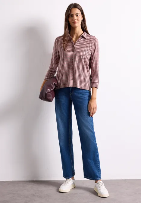 Shirt met 3/4-mouwen van jersey in blouse-stijl warm blush Frau in rosa Hemd, blauen Jeans und weißen Sneakern vor weißem Hintergrund.