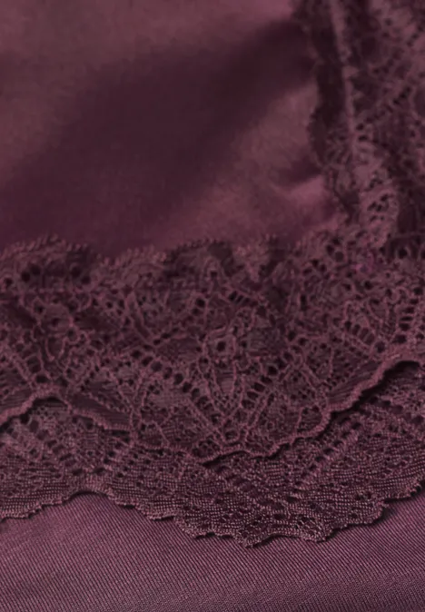 Nahaufnahme von dunkelrotem Satin mit floraler Spitze
