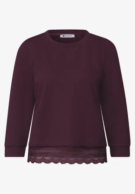 Dunkelvioletter Pullover mit Spitzenbesatz am Saum, Rundhalsausschnitt und langen Ärmeln.