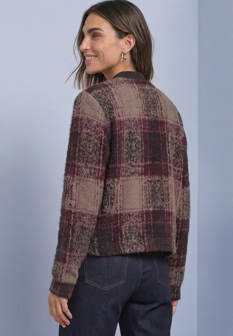 Rückansicht einer Frau in kariertem Strick-Cardigan in Bordeaux und Beige, lässiger Stil.