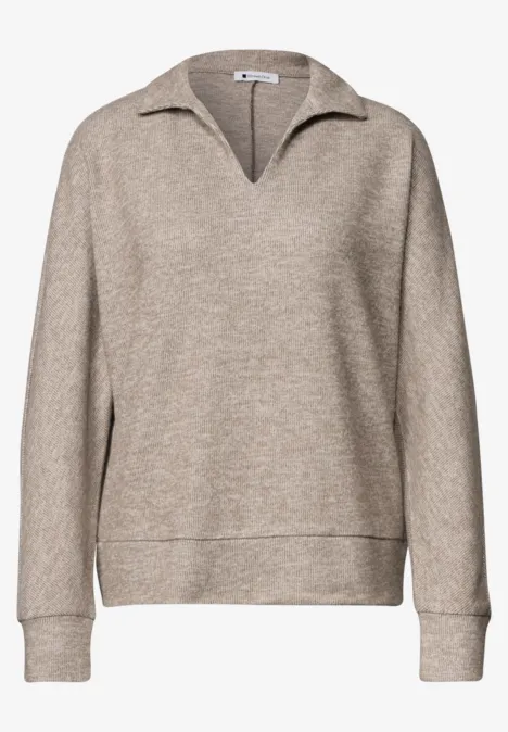 Pull beige à col V, manches longues et coupe décontractée.