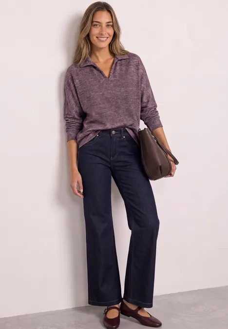 Koszulka Polo z długim rękawem w stylu melanżowym rustic rouge mel. Kobieta w fioletowym swetrze i ciemnych dżinsach z brązową torbą na białym tle.