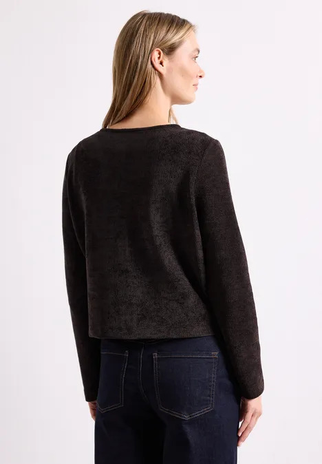 Veste à manches longues, col rond et boutons black coffee Frau von hinten im dunklen, langärmligen Pullover und Jeans vor weißem Hintergrund.