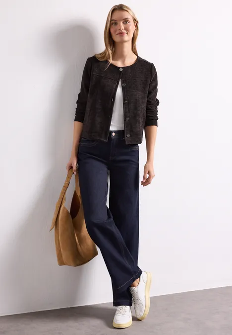 Veste à manches longues, col rond et boutons black coffee Frau in schwarzer Jacke, weißem Top, weiten Jeans und weißen Sneakern mit großer Tan-Tasche