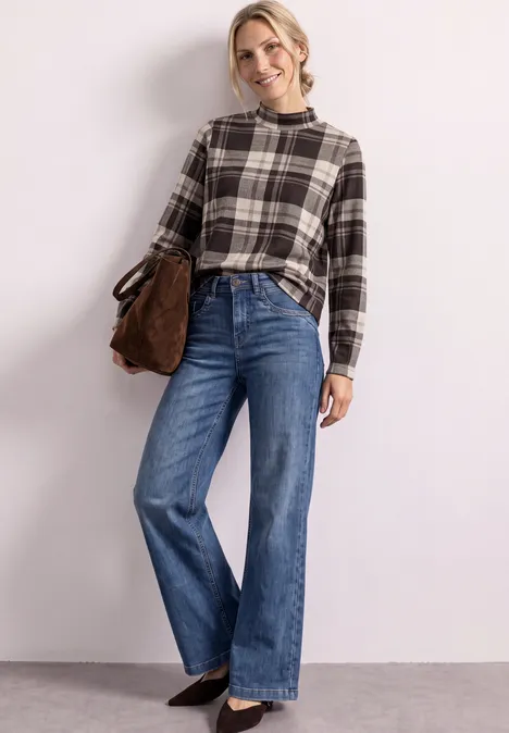 Langarm Shirt mit Turtle Neck und Karomuster black coffee Eine lächelnde Frau trägt eine karierte Bluse, weite Jeans und eine Umhängetasche vor hellem Hintergrund.