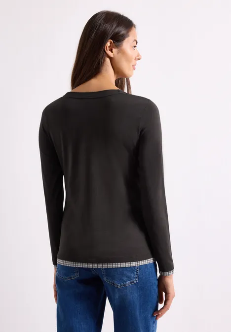 Langarm Shirt mit karierten Meshdetails black coffee Frau von hinten in schwarzem Langarmshirt mit gesprenkeltem Saum und blauen Jeans